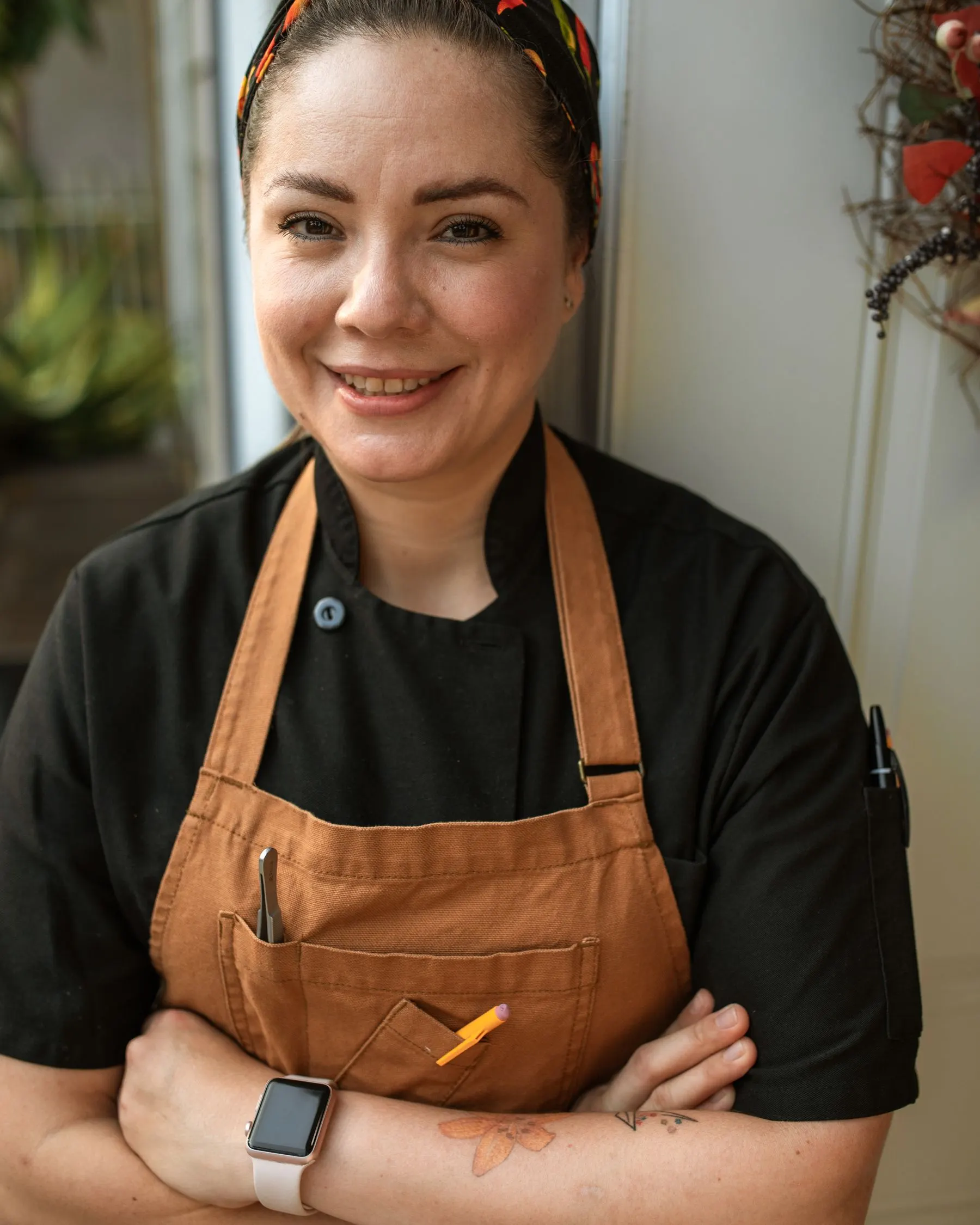 Chef Elif Yılmaz in an apron, photographed in a restaurant dining room